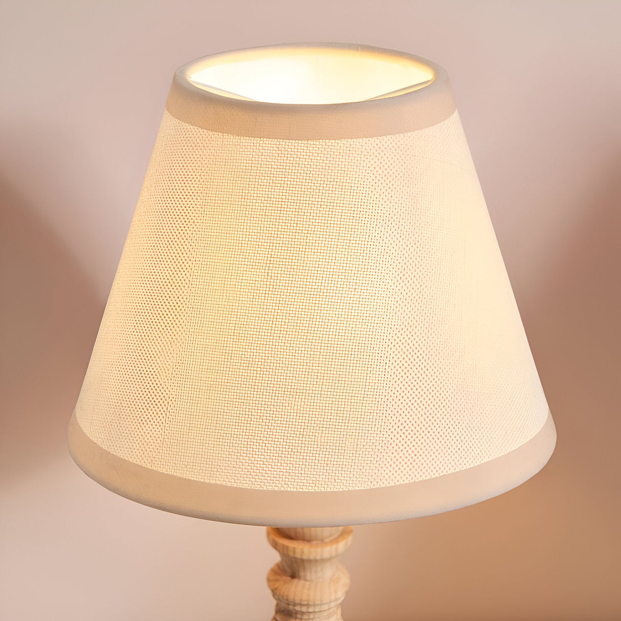 Endon Aldworth table lamp shade close-up in vintage white cotton mix fabric with almond white taped edge, illuminated on turned natural ash base.