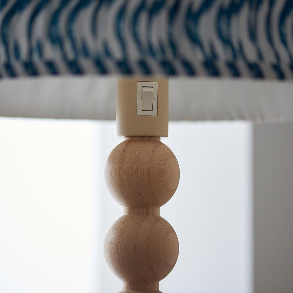 Close-up of the Endon Ashwood Floor Lamp showing stacked bamboo spheres, E27 holder switch, and marlin blue printed pleated shade edge.