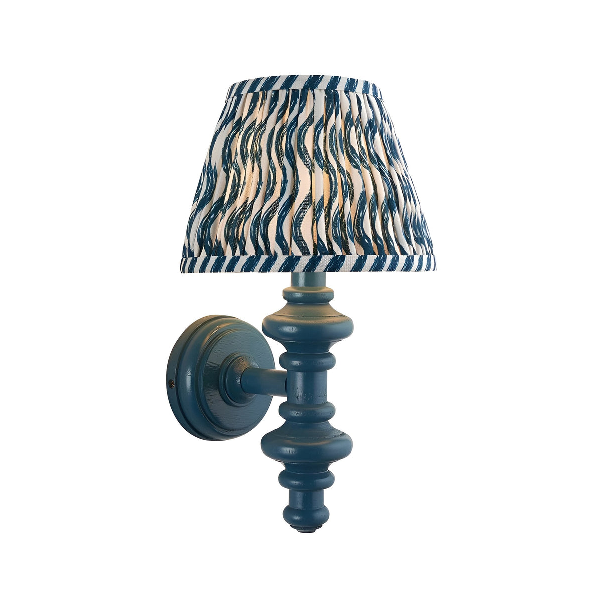 Endon Bevbury Ripple wall light with blue turned wooden spindle and tapered pleated shade in blue and cream ripple-print faux linen, on white.