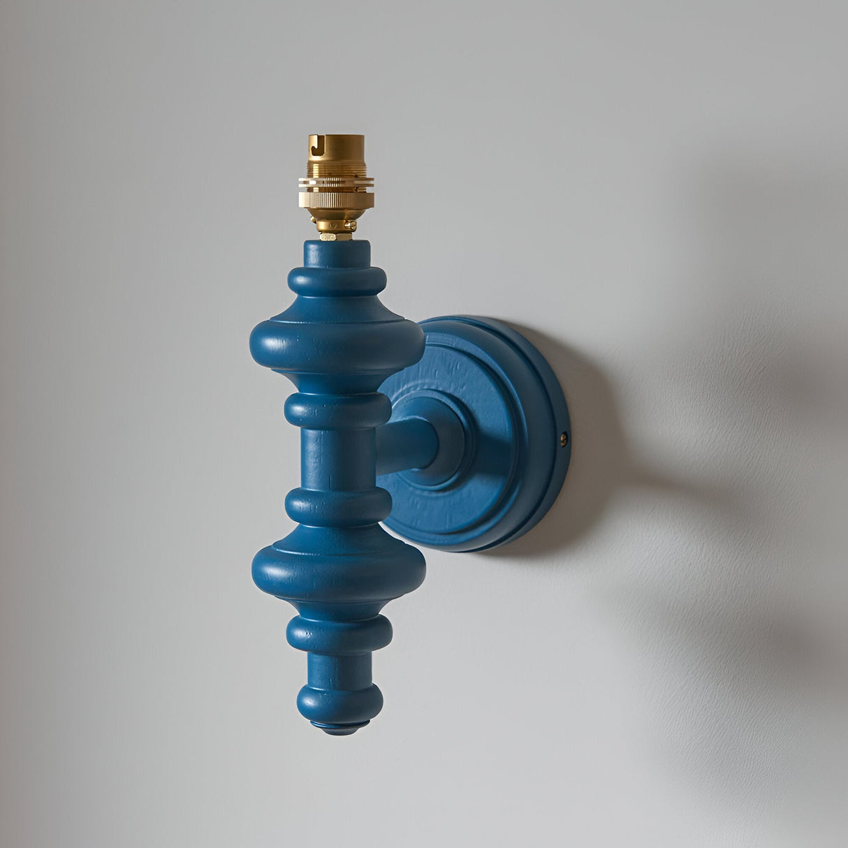 Endon Bevbury Ripple wall light base in marlin blue turned wood spindle with brass B22 lamp holder, shown without shade on a light background.