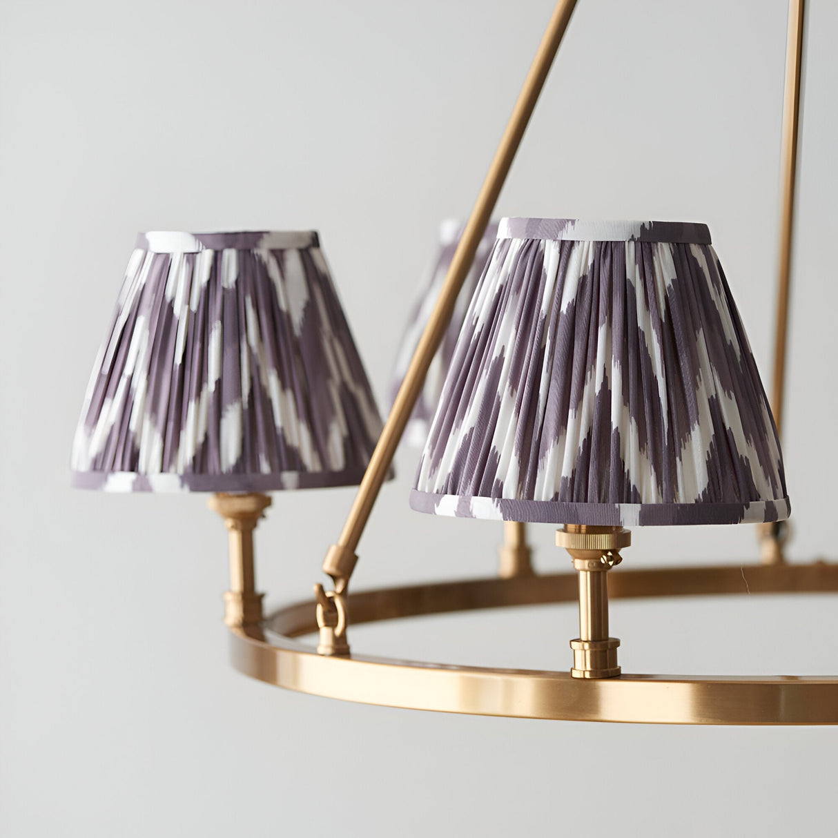 Close-up of Endon Bevford Zigzag 6 Light Pendant showing two pleated pearl grey zigzag fabric shades on an aged brass hoop frame with B22 holders.