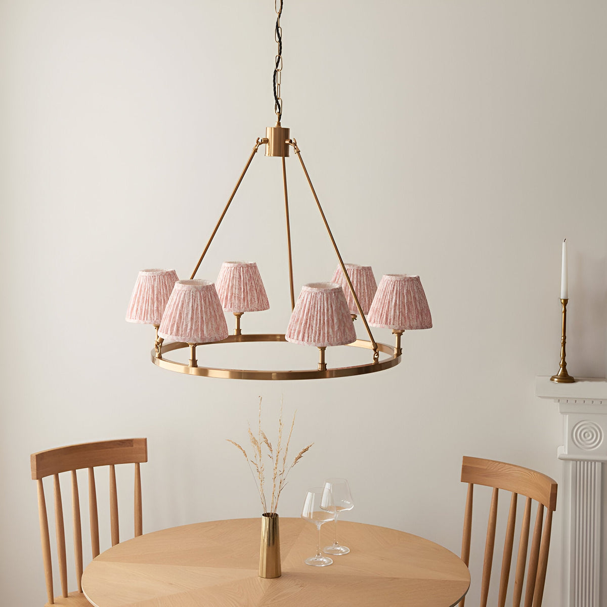 Endon Bevford Leaf 6 light pendant with aged brass hoop and pleated peach faux linen shades, above a wooden dining table and chairs.