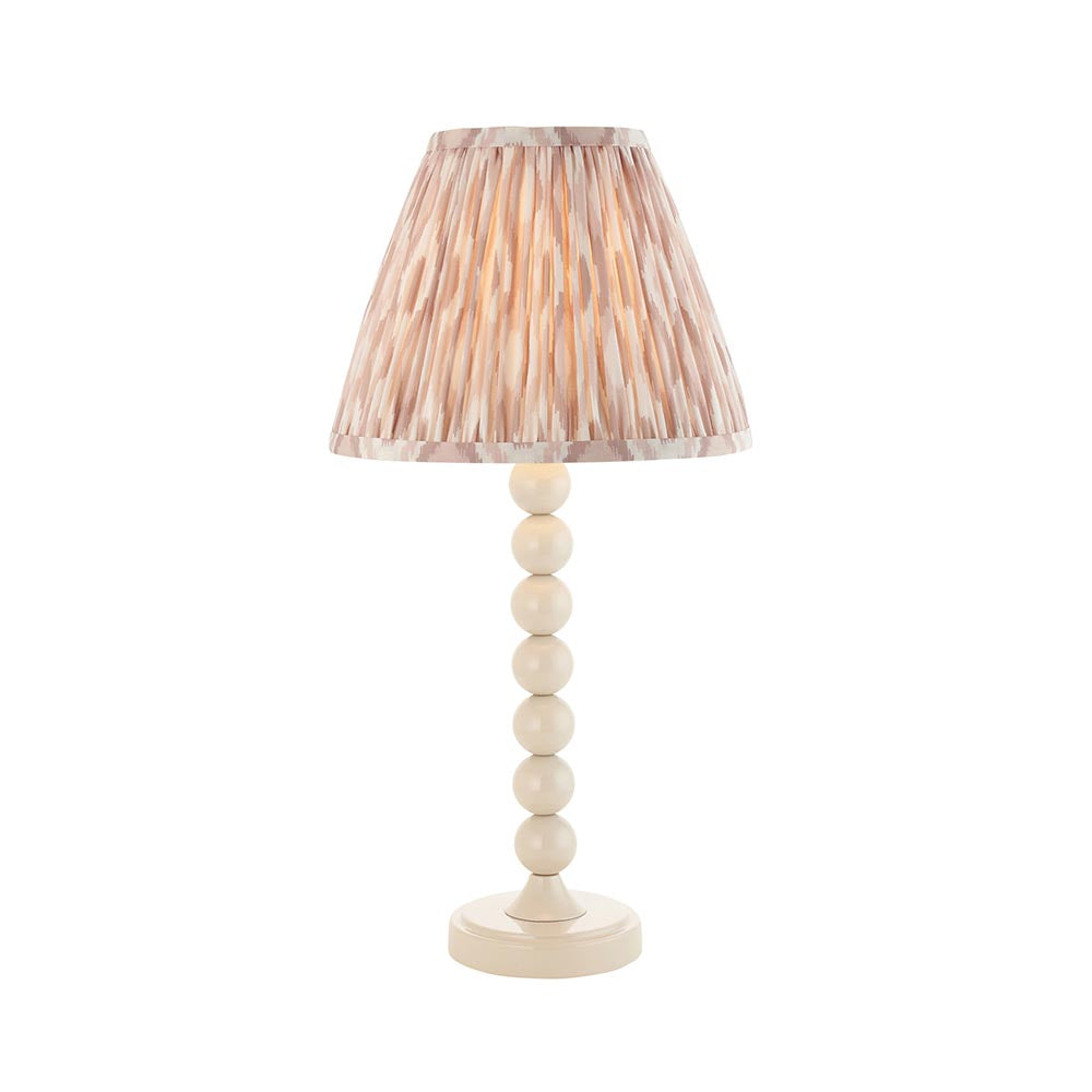 Brenleigh Ikat table lamp with white gloss stacked-sphere metal base and pleated natural Ikat-print fabric shade, on a plain white background.
