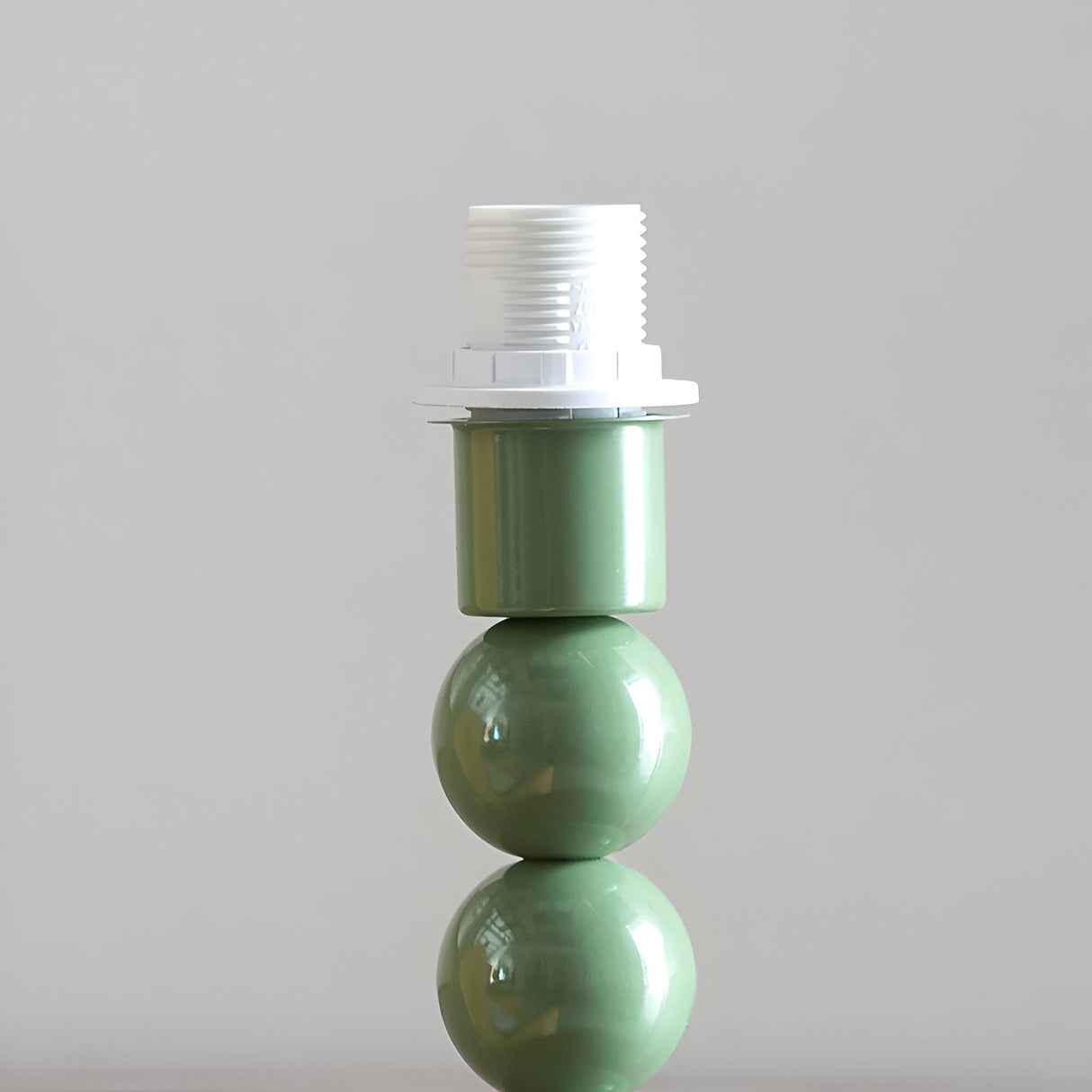 Close-up of the Endon Brenleigh Ripple table lamp base showing stacked green gloss spheres with a white E14 lampholder fitting on top.