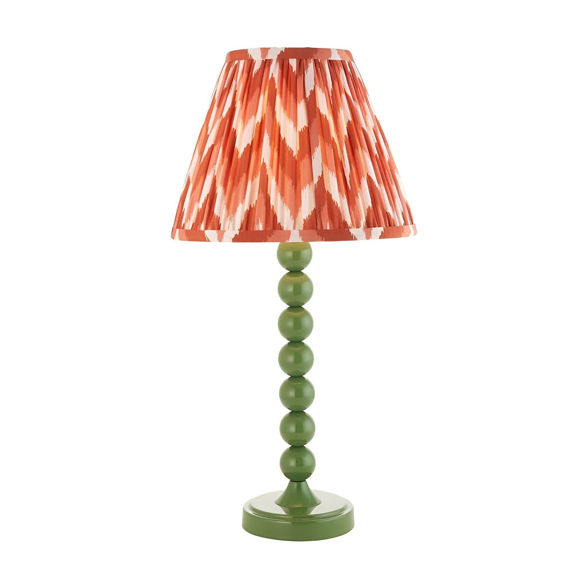 Brenleigh Zigzag table lamp with a green stacked-sphere metal base and a pleated orange zigzag-print fabric shade, shown on a plain white background.