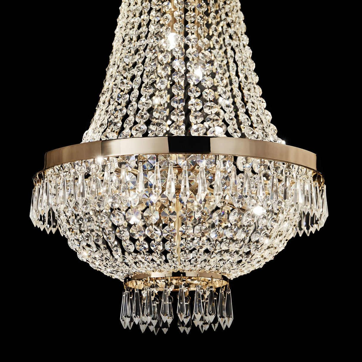 Introducing the Silhouette Crystal 9 Light Chandelier in Gold, a stunning masterpiece with its tiered design. It features an array of sparkling crystal elements that hang elegantly from its gilded structure. These crystals beautifully capture and reflect light, creating a dazzling spectacle against a dark backdrop—truly representing the pinnacle of luxury lighting.