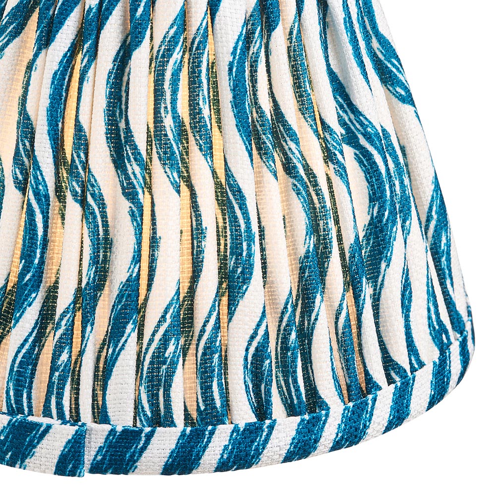 Close-up of the Ashstead LED Ripple Table Lamp shade in white fabric with teal wave print and gold metallic stripes, pleated with brass trim.