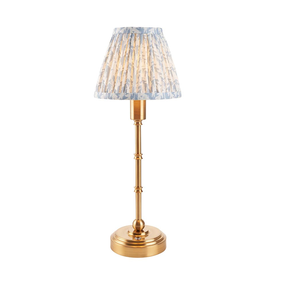 Ashstead LED table lamp with a slender brass stem, round base, and a pleated leaf-print fabric shade in white and blue, shown on a plain white background.