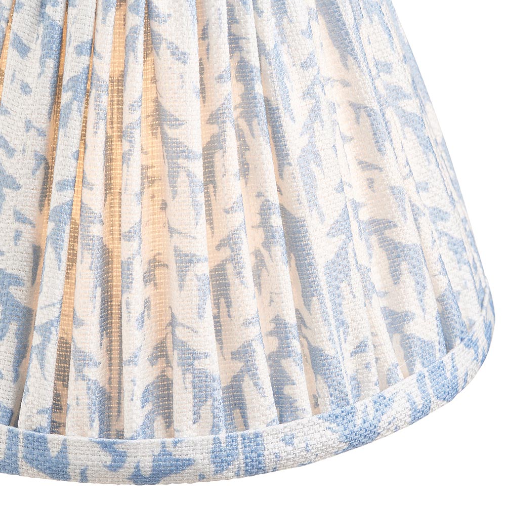 Close-up of the Ashstead LED Leaf Table Lamp's pleated fabric shade, showing a blue and white leaf print with brass lining and piped trim.