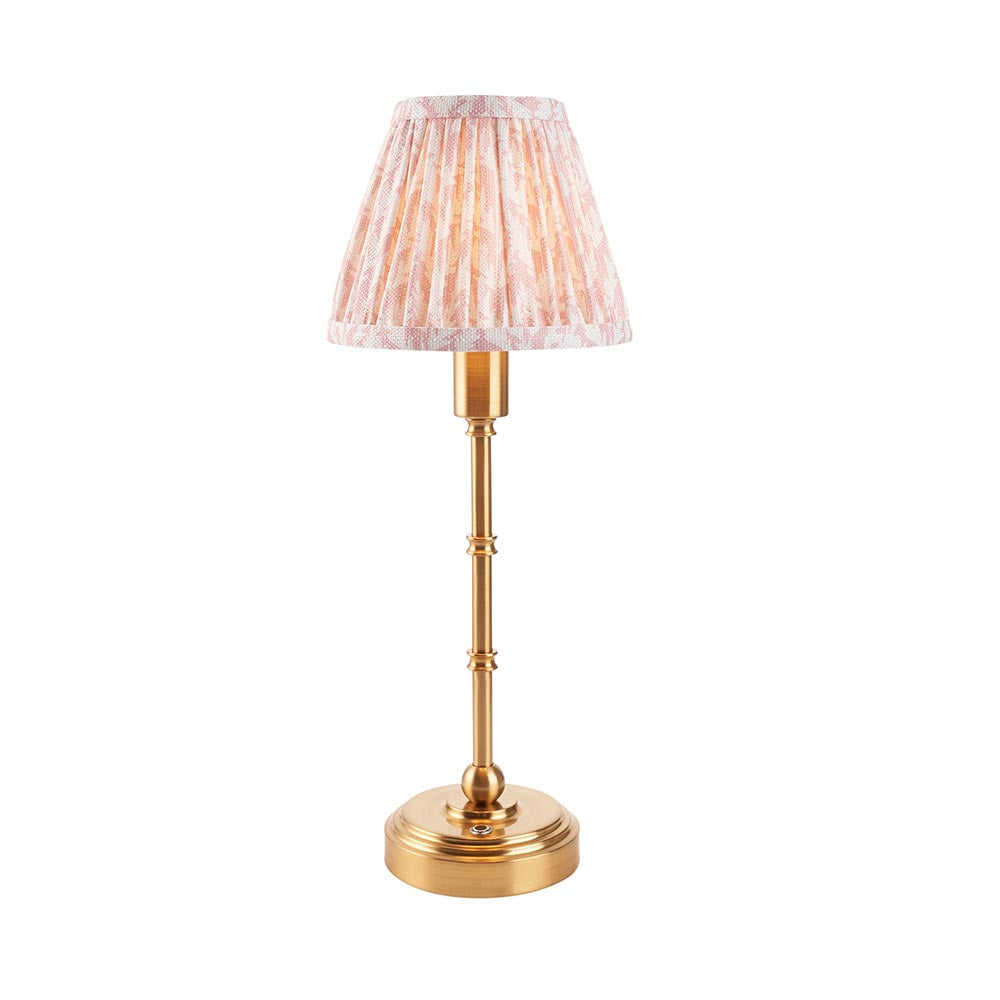 Endon Ashstead LED table lamp with brushed brass slim stem, round base and pleated pink leaf-print fabric shade, shown on a plain white background.