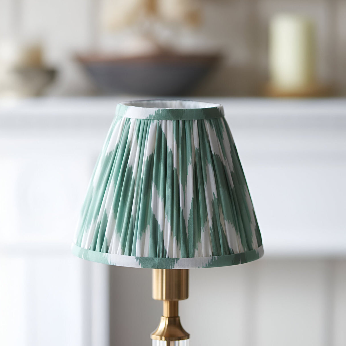 Carlwood LED Table Lamp in Green with a pleated zigzag fabric shade, brushed brass base, and clear acrylic detail.