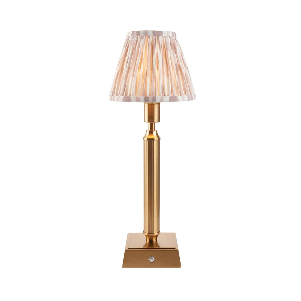 Cranwick LED Ikat table lamp with reeded brass stem, square base, touch dimmer, and pleated ivory-striped fabric shade on a plain white background.