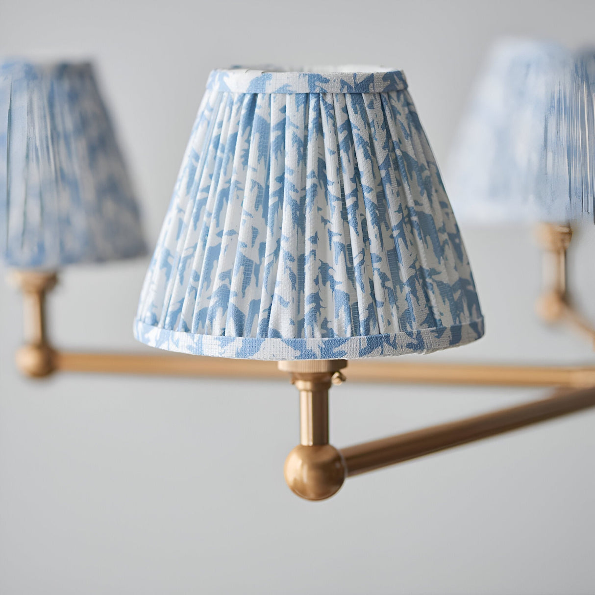 Endon Cliffleigh Leaf pendant detail showing a pleated tapered shade in blue leaf print on faux linen, mounted to a brushed aged brass arm.