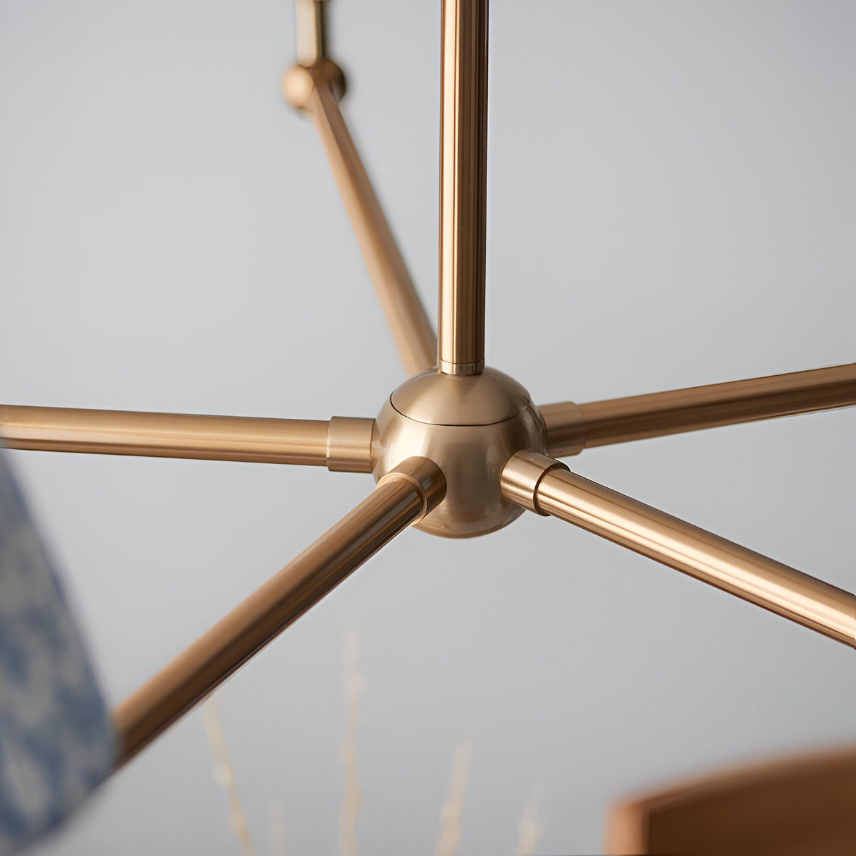 Close-up of the Endon Cliffleigh Leaf 5 Light Pendant centre hub, showing brushed aged brass arms radiating from a spherical joint.