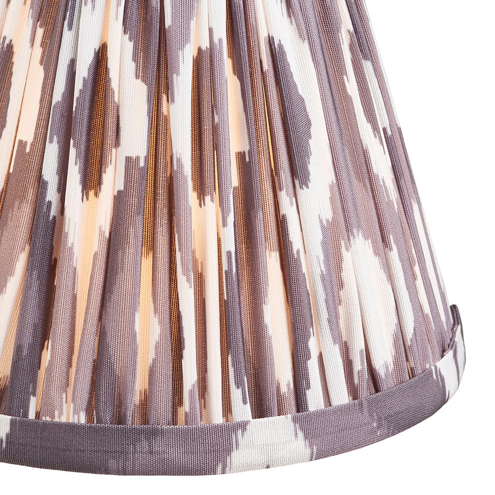 Close-up of the Cliffleigh Ikat pendant light's pleated fabric shade in grey and cream Ikat pattern with brass fittings and taped edge trim.