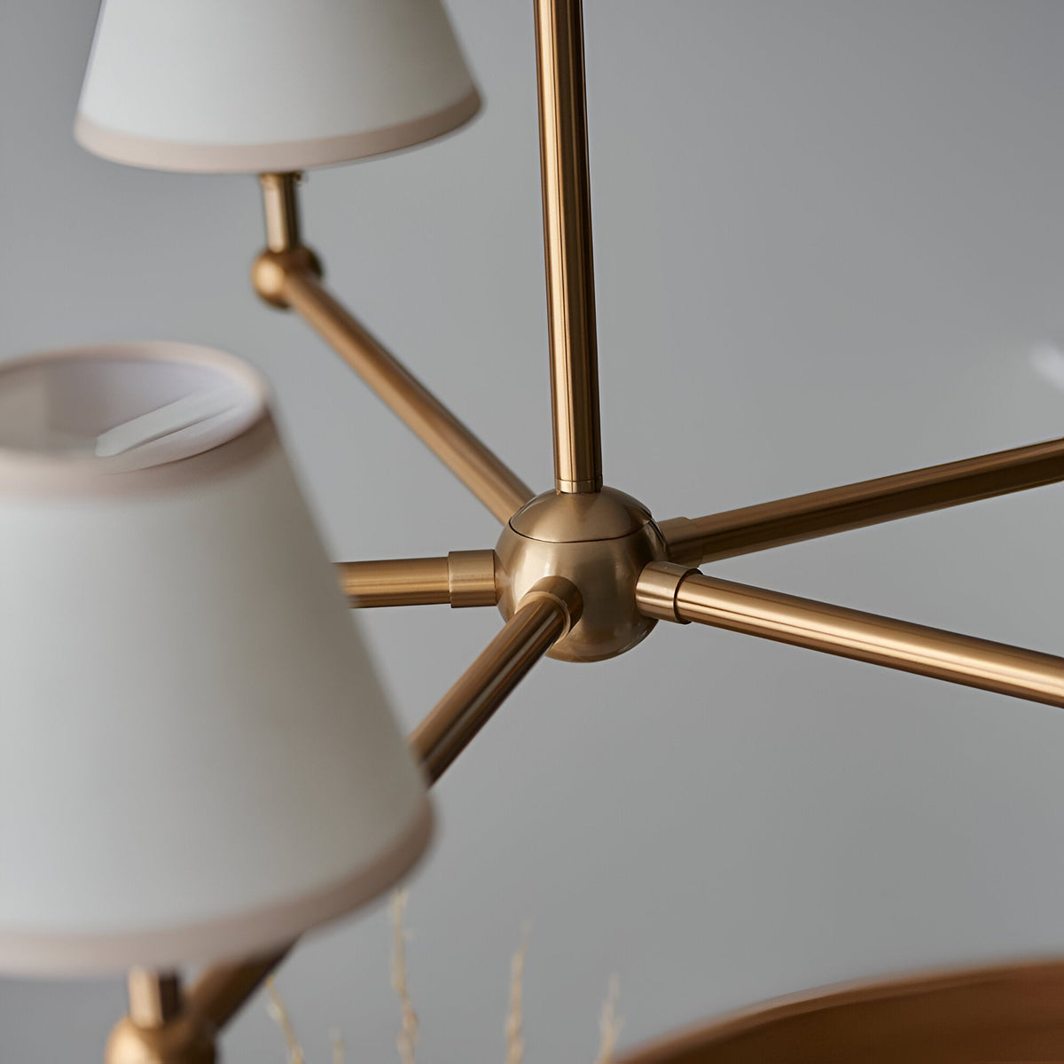 Close-up of Endon Cliffleigh 5 Light pendant showing brushed aged brass central hub, radiating arms, and tapered white cotton shades with taped edges.