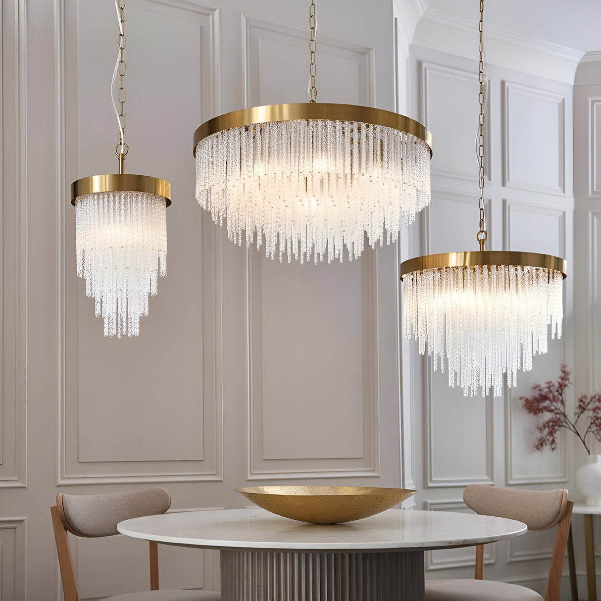 Aldfield Pendant in brass, shown in a dining room with two larger tiered pendants, featuring twisted clear glass rods beneath a brushed aged brass frame.