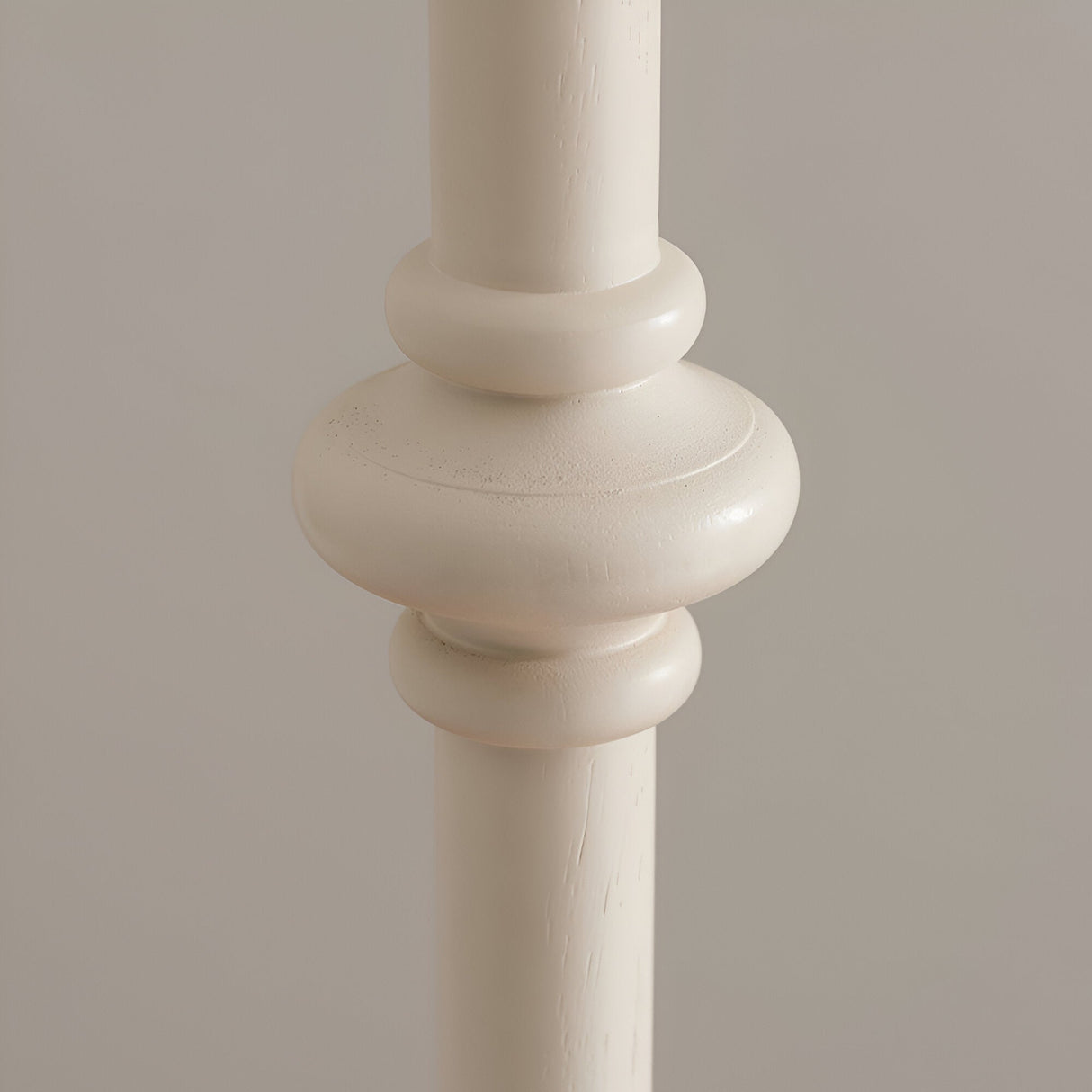 Close-up of the turned spindle detail on the Endon Bevbury floor lamp, showing the almond white painted wood base against a neutral background.