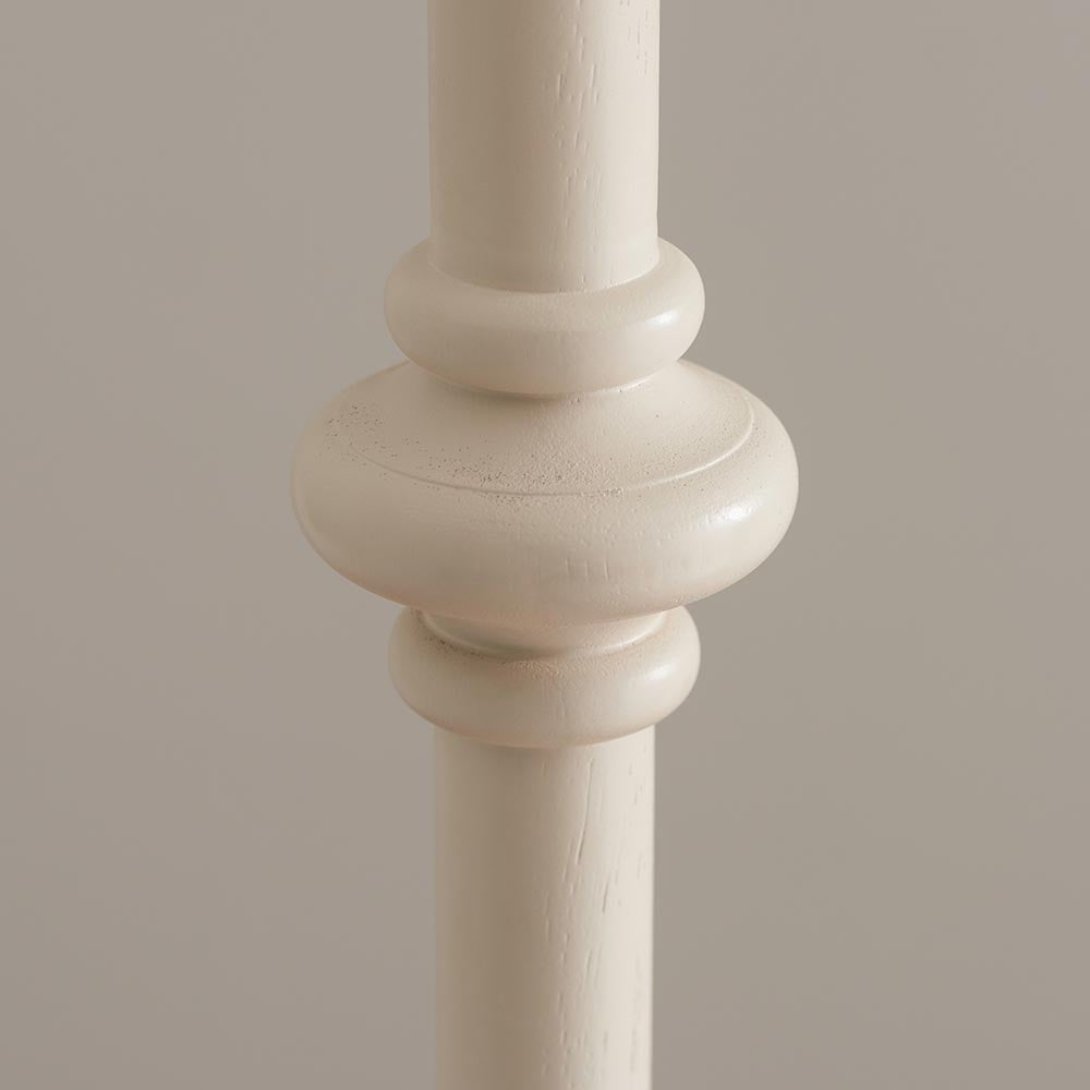 Close-up of the Bevbury Ikat Floor Lamp's turned wooden spindle base in white, showing carved detailing against a neutral background.