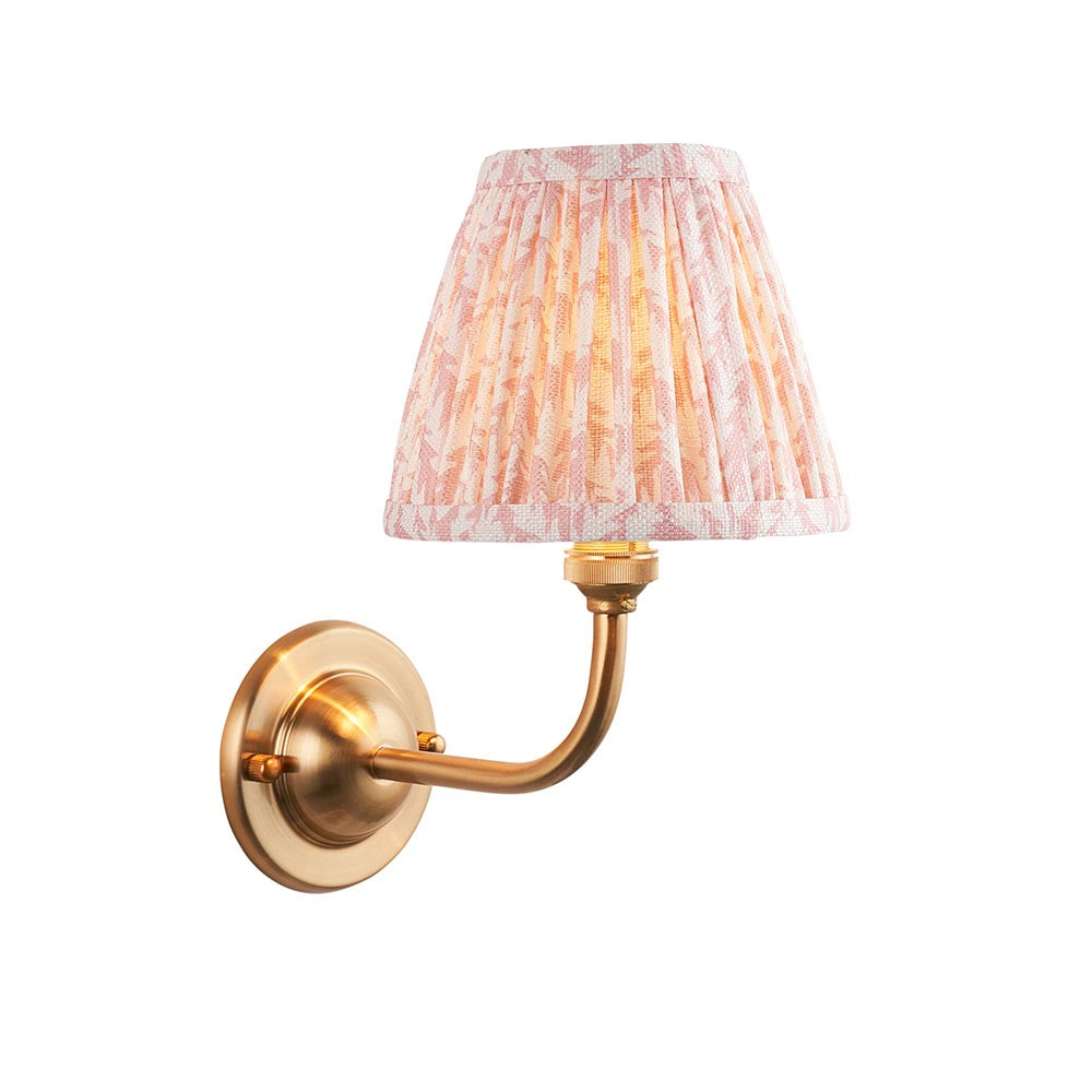 Brackdale Leaf wall light in brushed brass with curved arm and pleated pink leaf-print fabric shade, shown on a plain white background.