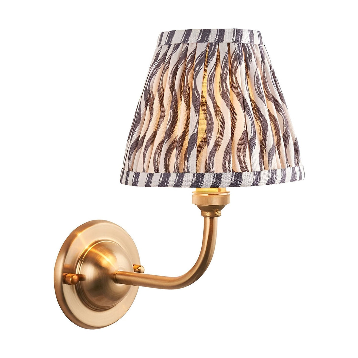 Endon Brackdale Ripple wall light in brushed aged brass with a pleated tapered shade in pearl grey faux linen ripple print, on a white background.