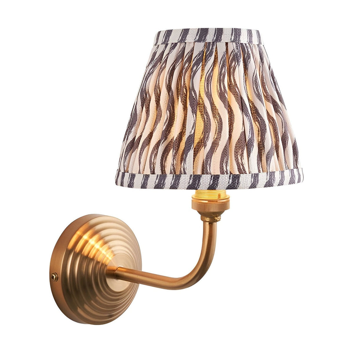 Endon Castgrove Ripple wall light with brushed aged brass stepped backplate, curved arm, and grey rippled pleated fabric tapered shade on white.