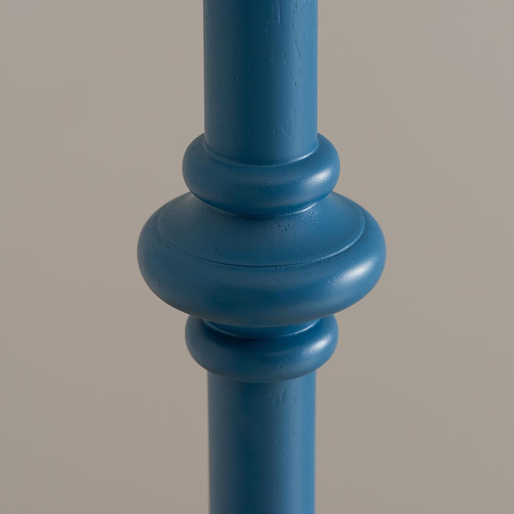 Close-up of the Endon Bevbury Ripple floor lamp's turned wooden spindle base in marlin blue satin paint, showing shaped rings against a light grey background.