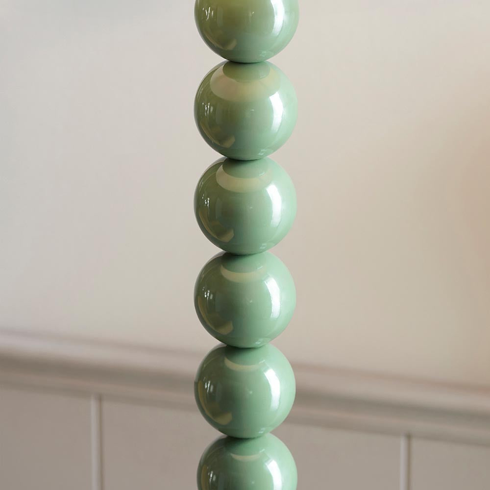 Brenleigh Ikat Floor Lamp base close-up showing stacked glossy green ceramic spheres, set against a plain light background.