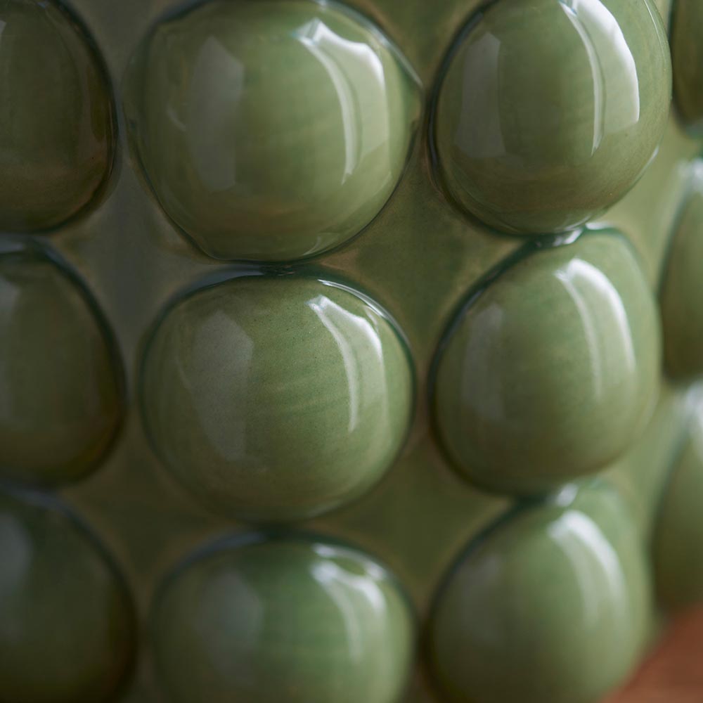 Close-up of the Amberley Ripple Table Lamp's ceramic bobble base showing its glossy green sculptured bobble texture.
