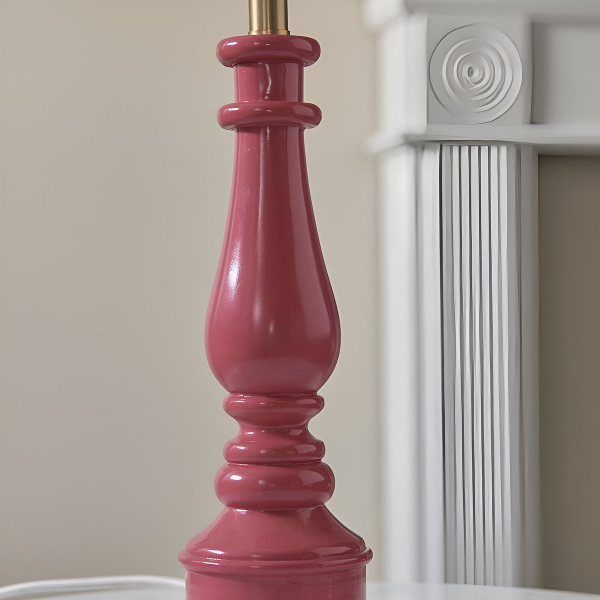 Carlworth Zigzag Table Lamp base in glossy pink clay resin with turned spindle detailing and brass-tone fitting, shown against a neutral interior.
