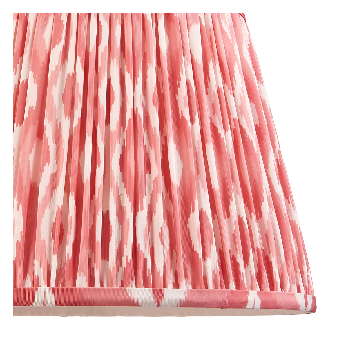 Close-up of the Amberley Ikat Table Lamp's pleated fabric shade in pink and white ikat pattern with pink trim edging.