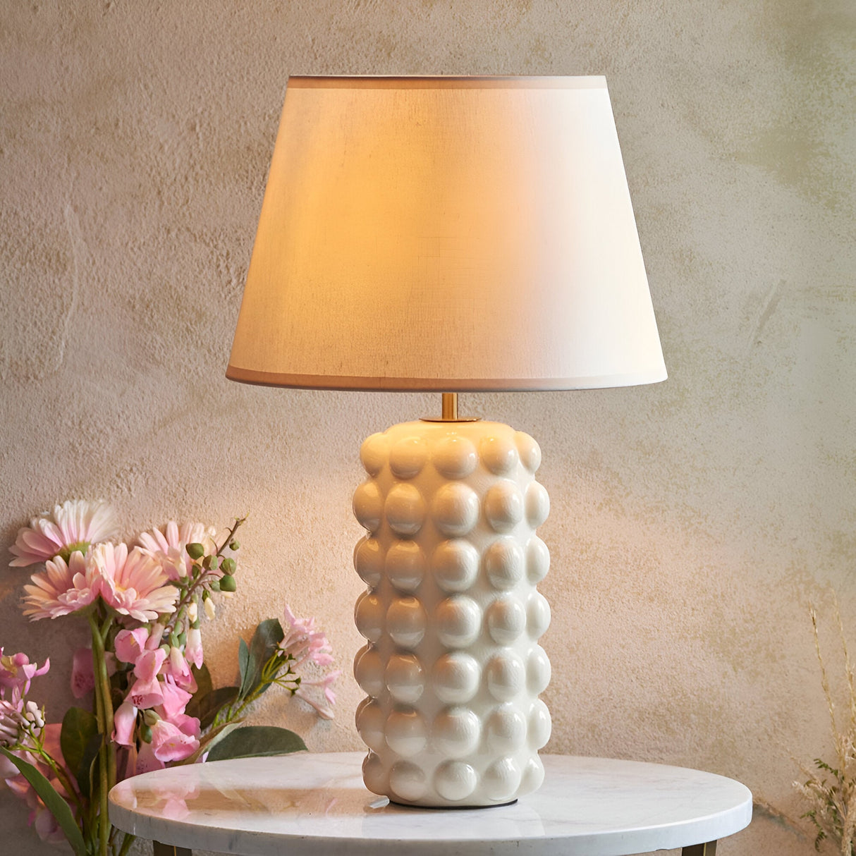 Endon Amberley Ivy table lamp with white crackle-glazed ceramic bobble base, aged brass stem and tapered ivory fabric shade on a marble table.