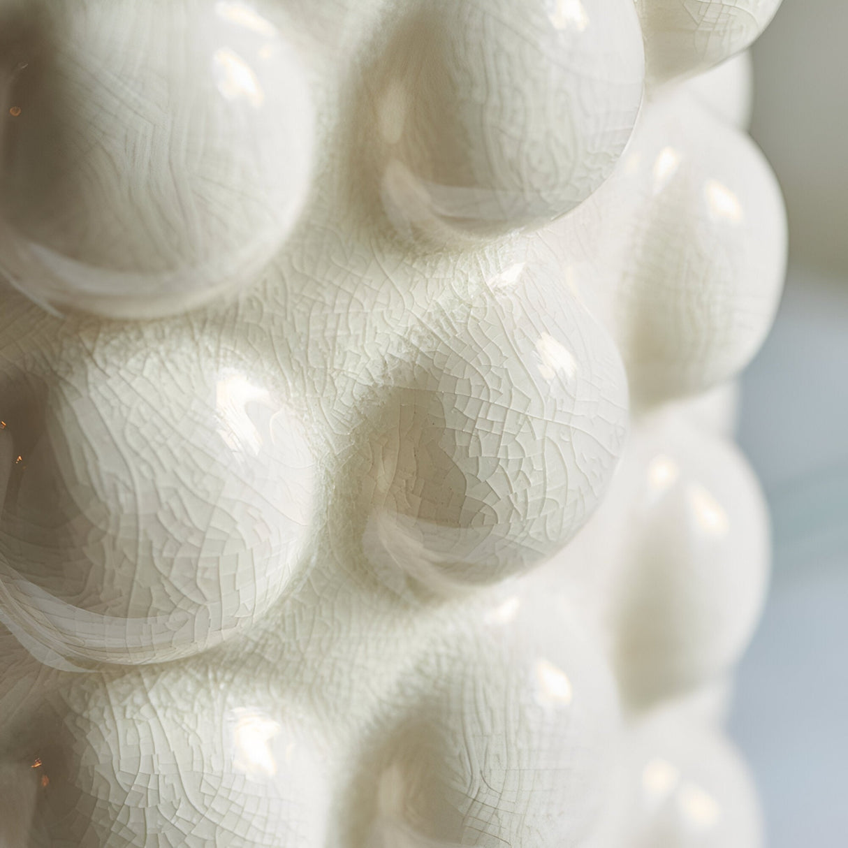 Close-up of the Endon Amberley table lamp's ceramic base, showing sculpted bobble shapes in a glossy vintage white crackle glaze.
