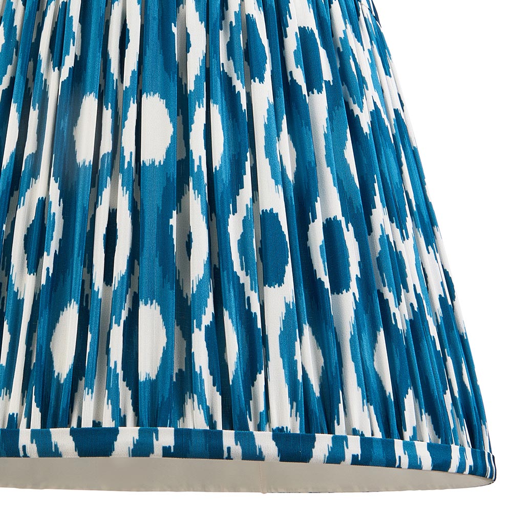 Close-up of the Endon Amberley Ikat table lamp shade, hand-pleated faux silk in marlin blue and white with a repeating ikat spot pattern.