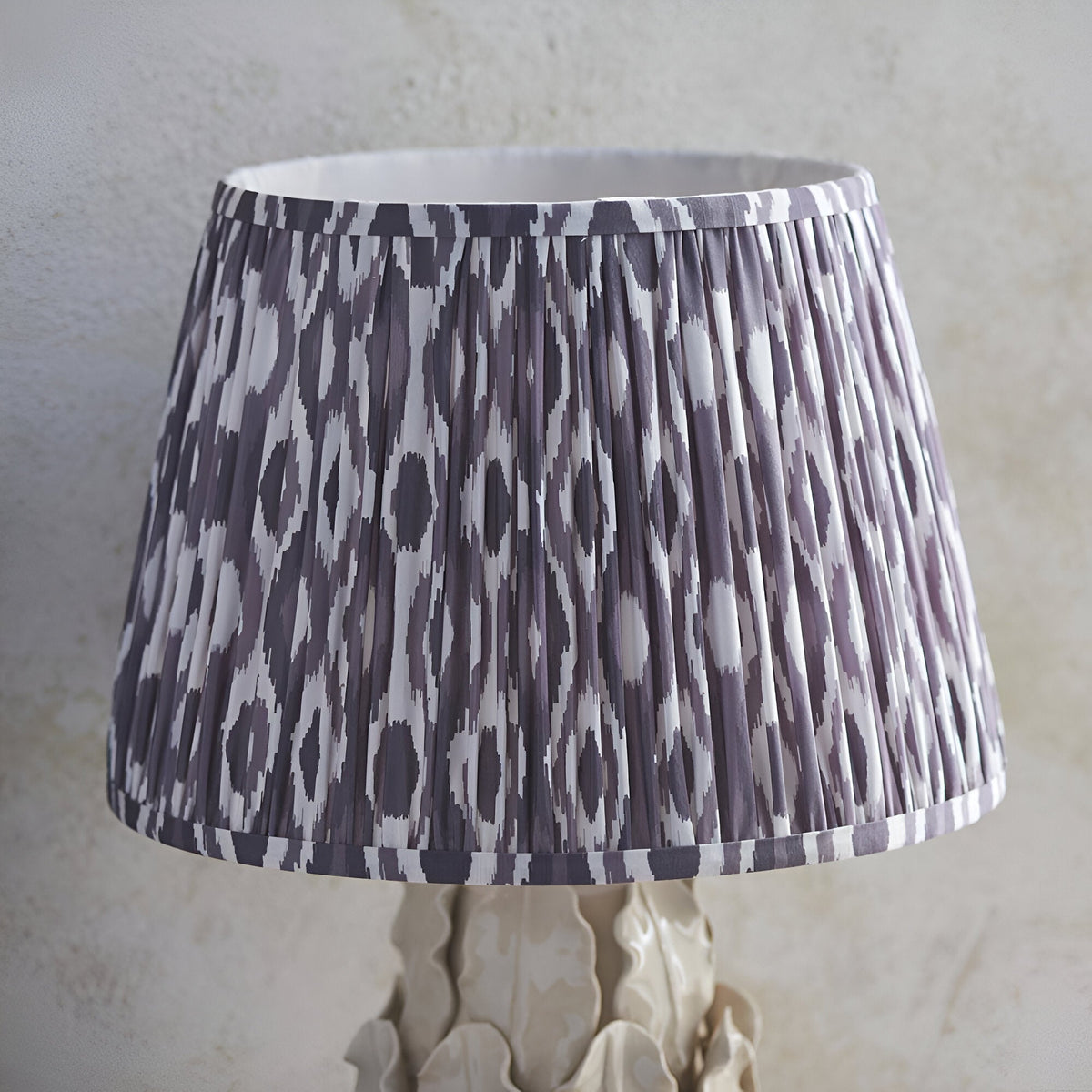 Endon Caldford 35cm table lamp with pleated grey and white Ikat faux silk shade on a sculpted ivory crackle-glaze ceramic base.
