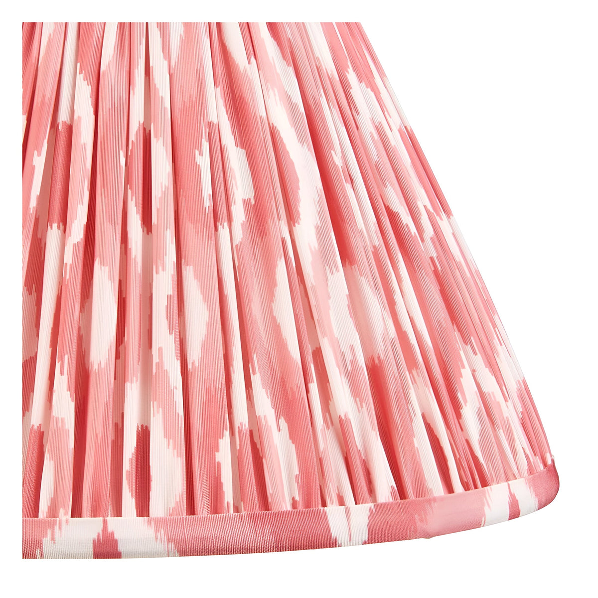 Close-up of the Carlstead Table Lamp's pleated Ikat shade in pink and white patterned fabric with a gathered finish and trimmed edge.