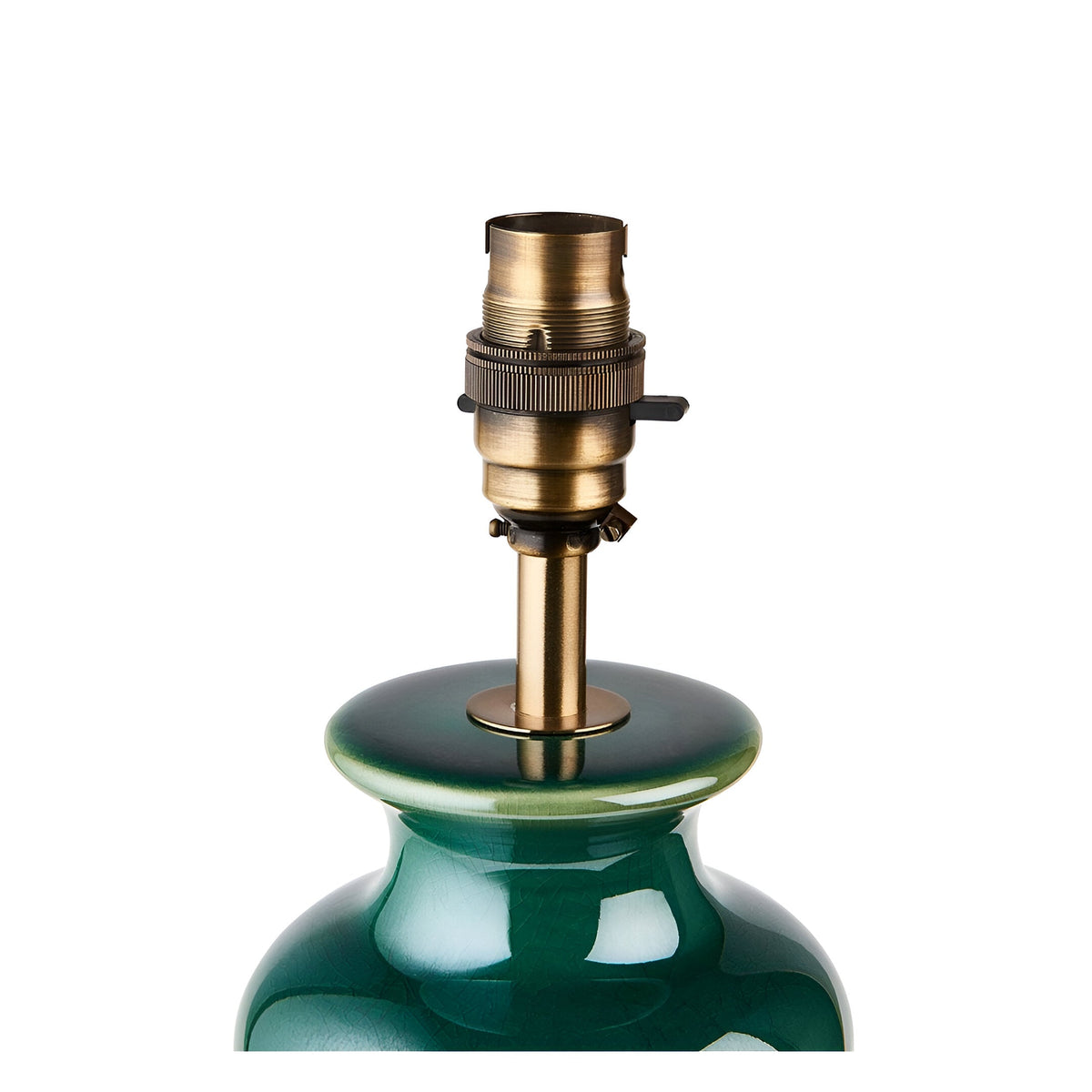 Close-up of the Carlstead Ivy Table Lamp's brushed aged brass B22 lamp holder atop a glossy green ceramic gourd-shaped base, on a white background.