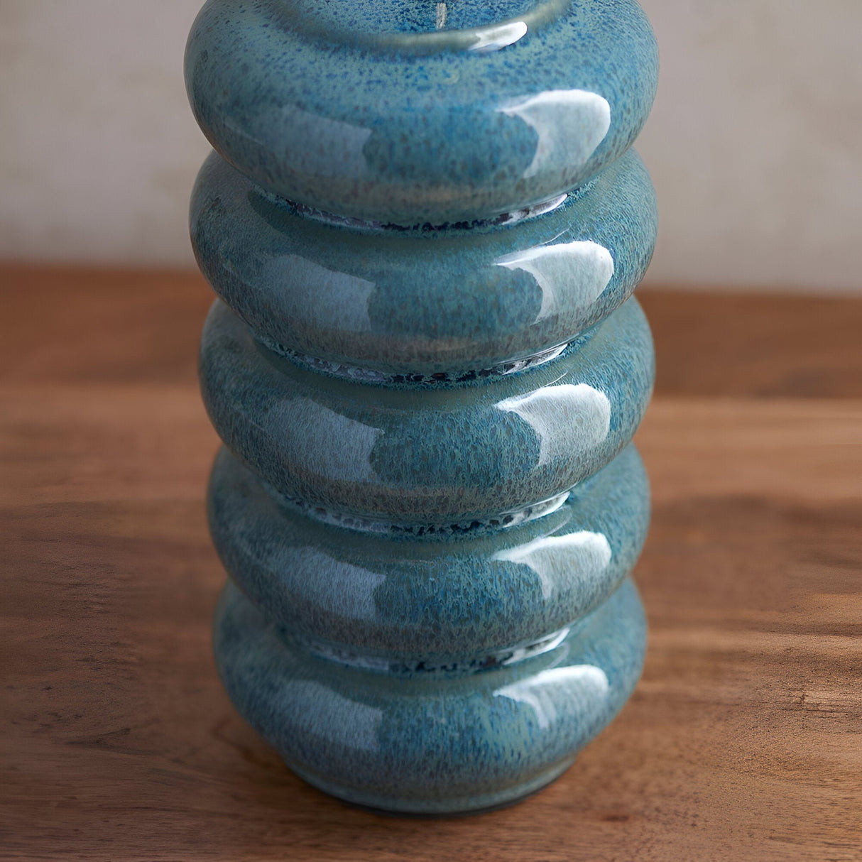 Close-up of the Endon Cliffstead ceramic table lamp base, showing stacked rounded tiers in an ocean spray blue-green reactive glaze on a wooden surface.