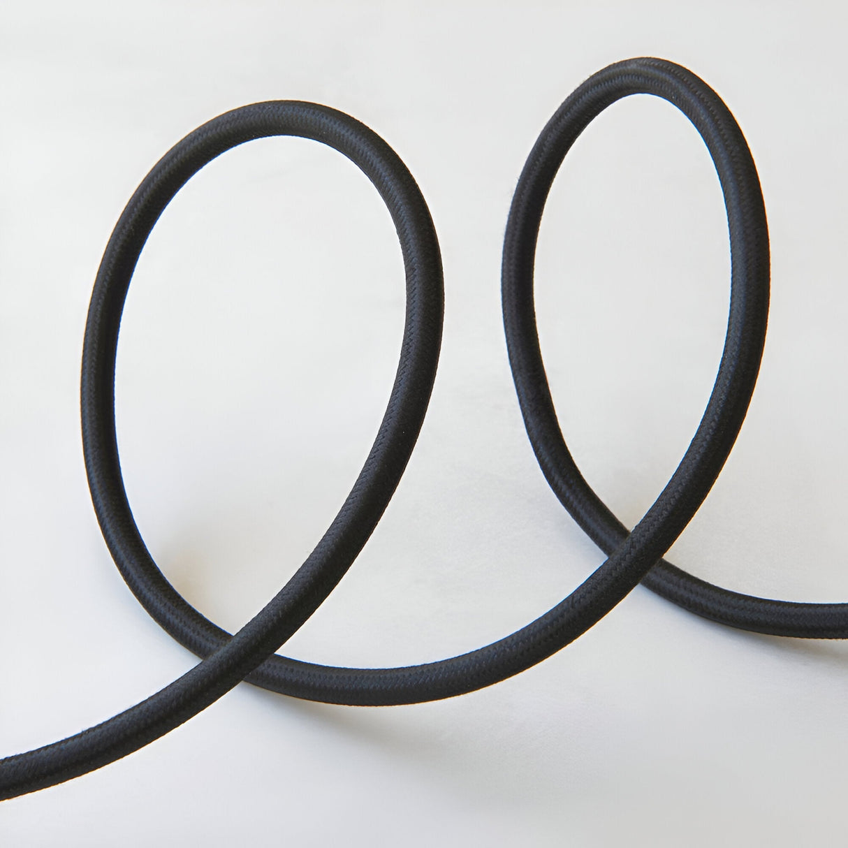 Endon Brackmont pendant flex set with black braided fabric cable looped in two curves on a plain white background.