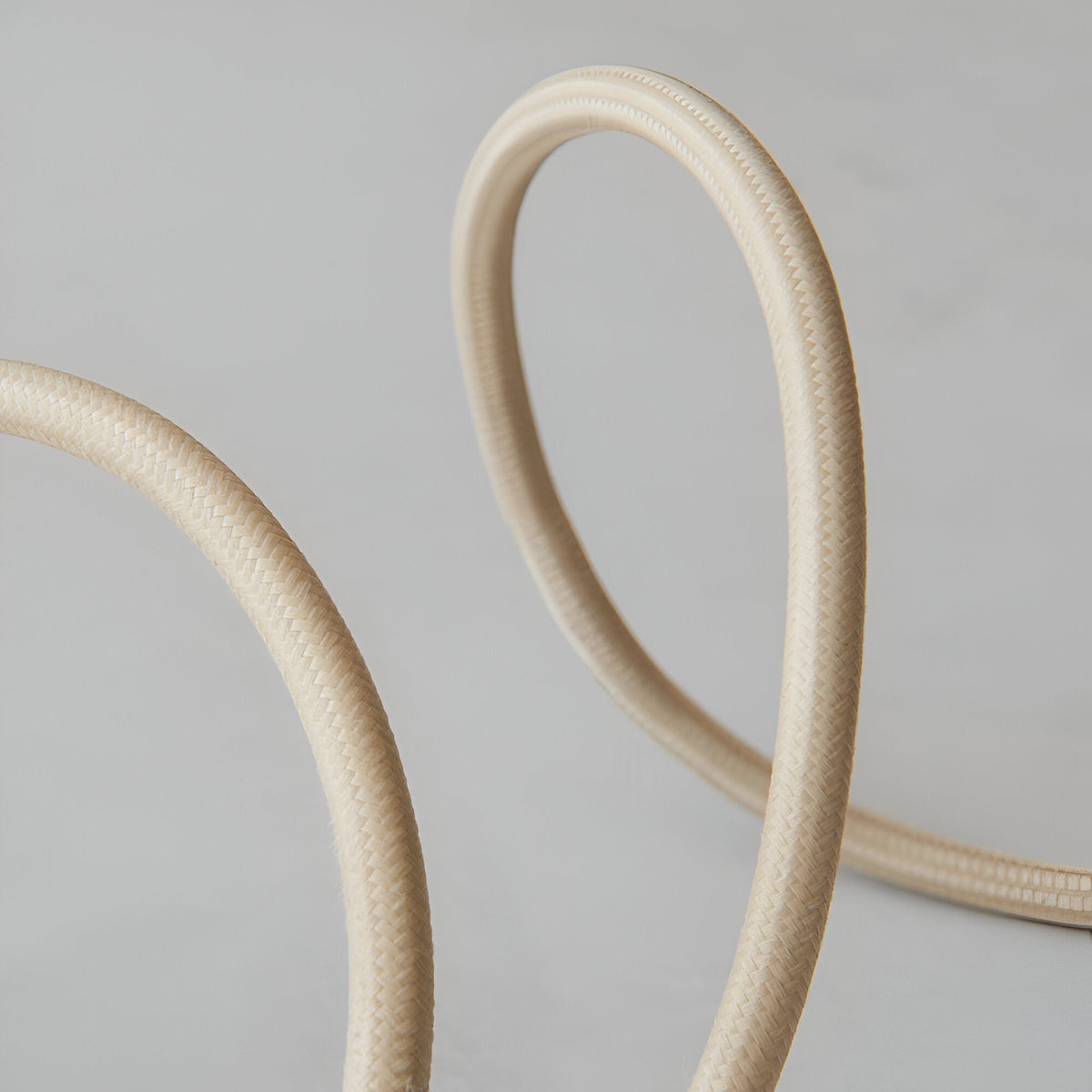 Close-up of the Endon Brackmont Flex Set in natural braided fabric cable, looped to show its woven texture against a light grey background.