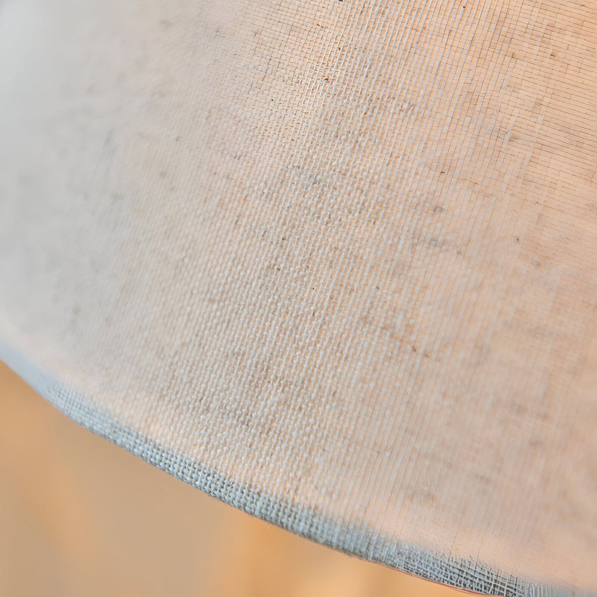 Close-up of the Endon Caldmont table lamp's tapered natural linen shade, showing the woven fabric texture and stitched lower edge.