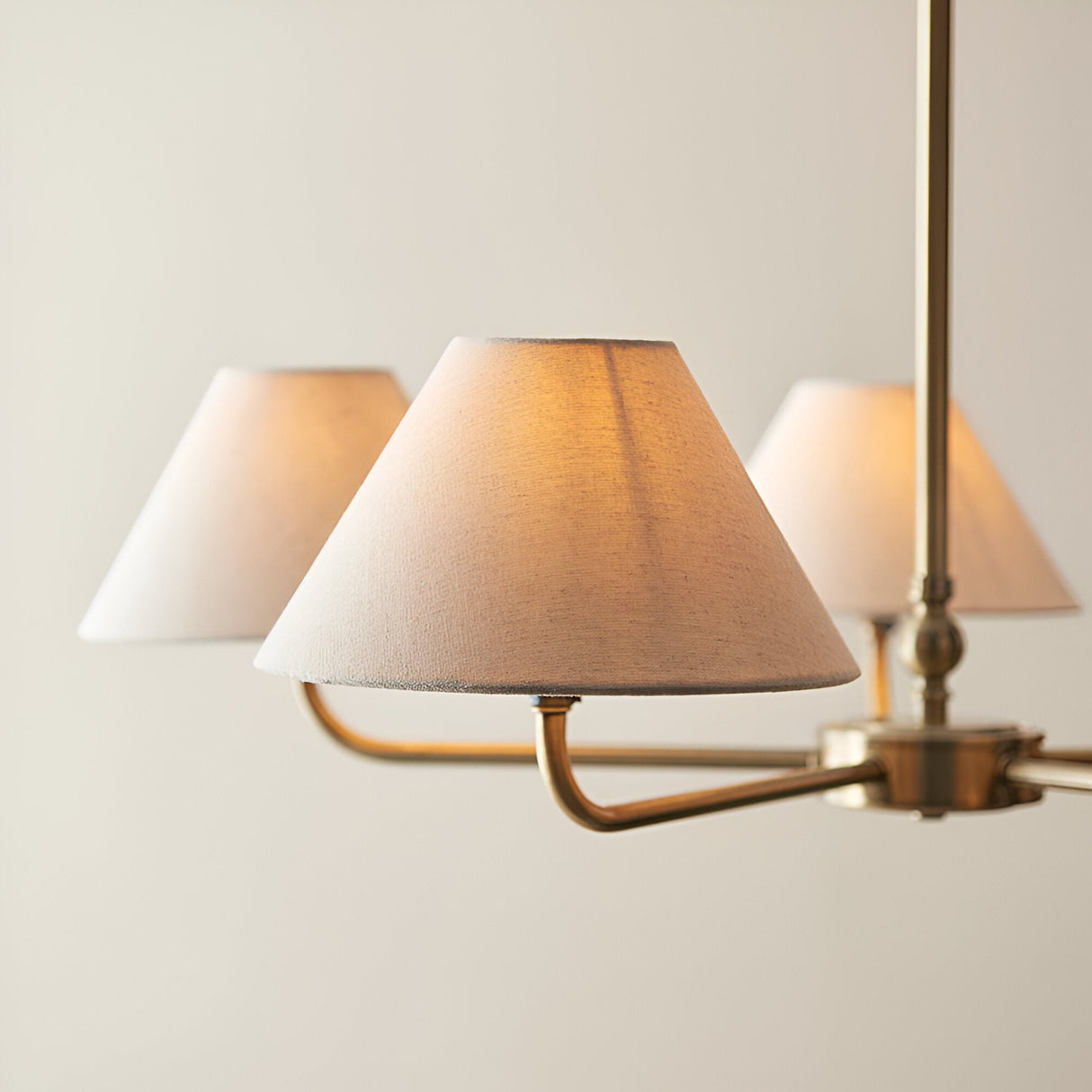 Close-up of the Caldmere 5 Light Large Pendant, showing brass arms and natural linen tapered shades against a plain light background.