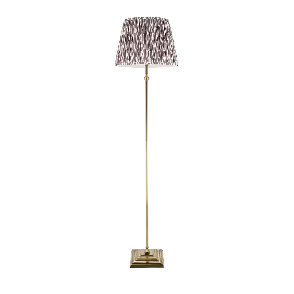 Caldmere Ikat Floor Lamp in grey with antique brass stem, square stepped base, and pleated Ikat-patterned fabric shade.