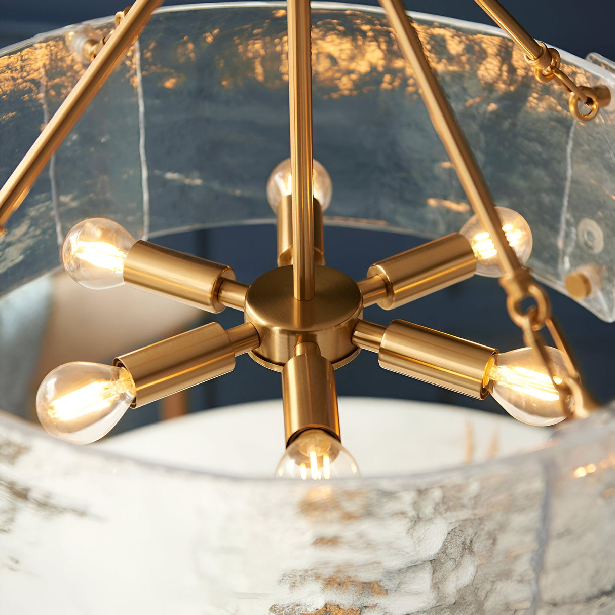 Close-up of Endon Brockmont 6 Light Pendant in brushed brass, showing the six-arm bulb cluster within a rippled handmade glass cylinder shade.