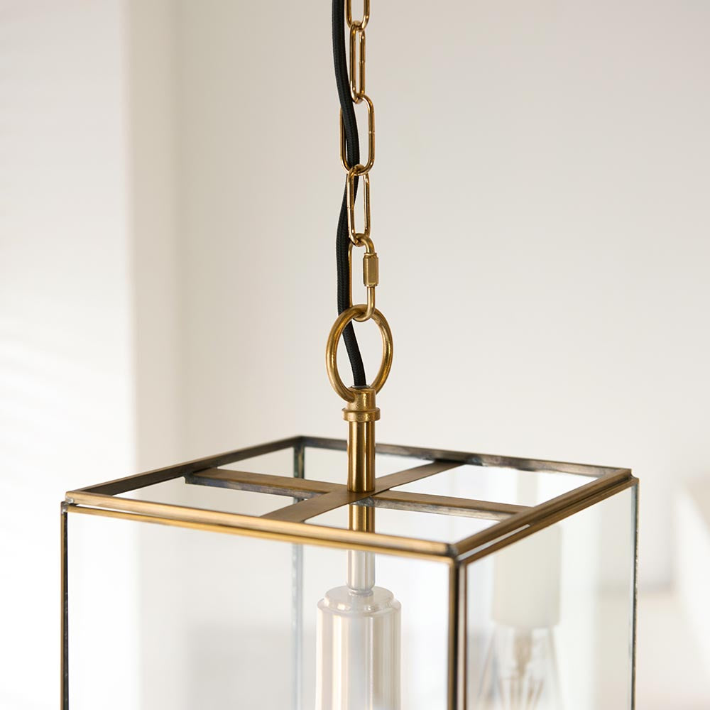 Endon Haddon Grand Pendant close-up in brushed aged brass, showing chain suspension, black fabric flex, square glass lantern top and E27 bulb holder.