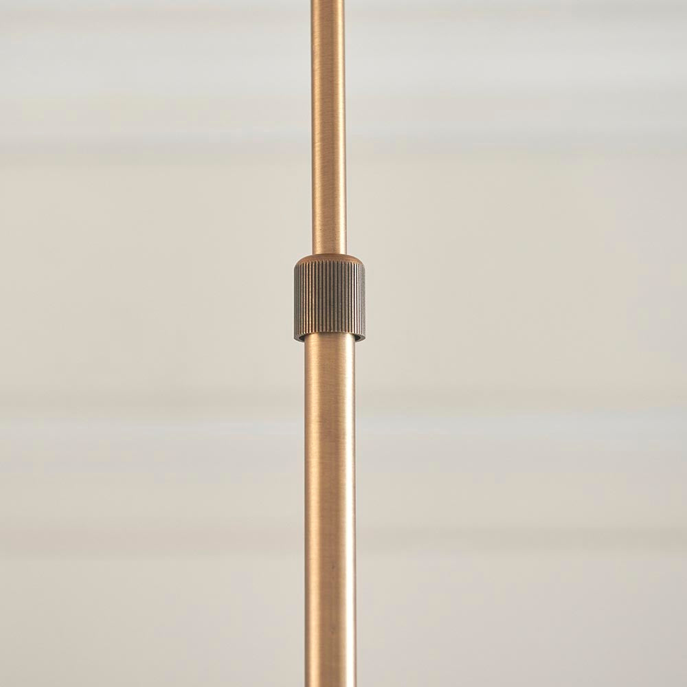 Close-up of the Endon Bramwick pendant's antique brass telescopic stem with a ridged adjustment collar, shown against a soft neutral background.