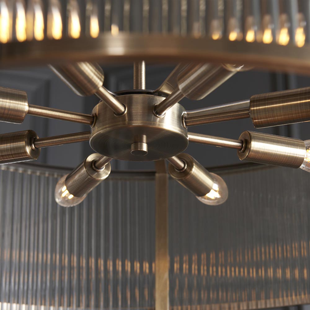 Close-up of the Endon Rothbury 8 Light Pendant in antique brass, showing the central hub, radiating arms, E14 lamp holders and ribbed glass panels.