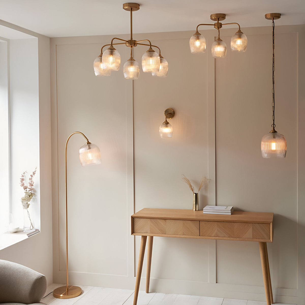 Endon Halstead floor lamp in aged brass with a curved stem and ribbed glass dome shade, shown alongside matching pendant, wall, and ceiling lights.