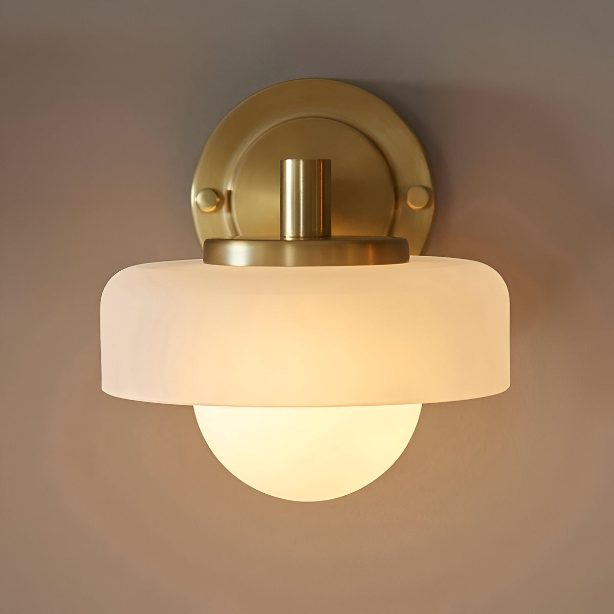 Endon Ashby wall light in brushed aged brass with a frosted glass outer shade layered over a matt opal glass sphere, mounted on a round backplate.
