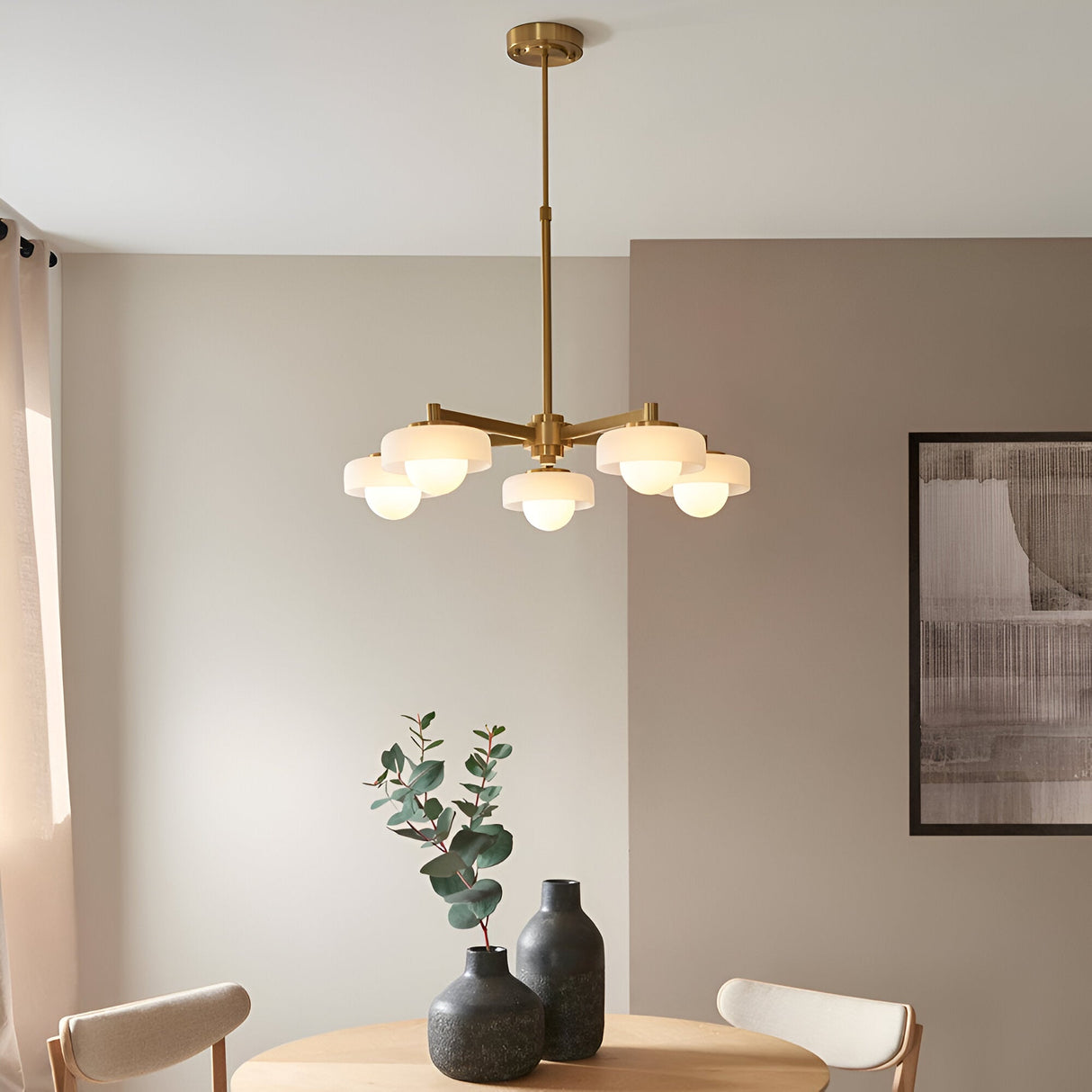 Endon Ashby 5 light pendant in brushed aged brass with frosted glass shades and opal globes, above a dining table in a neutral room.